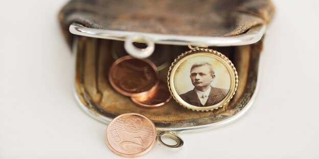Ein Portremonnaie mit geldmünzen und einem alten Portraitfoto