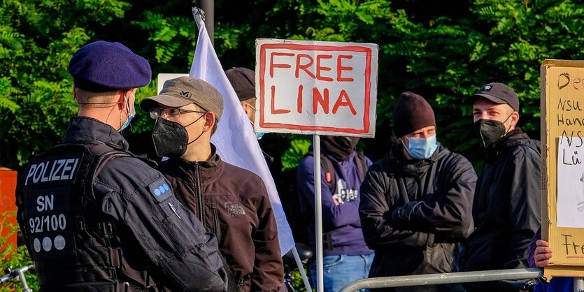 Eine Menschengruppe und ein Polizist, auf einem Plakat steht "Free Lina"