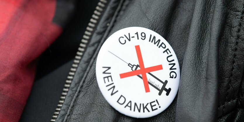 Ein Button an einer Jacke: Covid-Impfung nein Danke