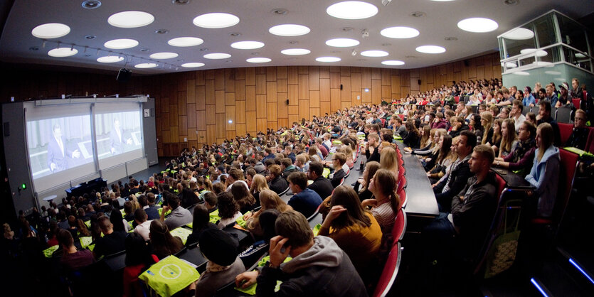 Studenten sitzen bei der Erstsemesterbegrüßung im Audimax in der Leibniz Universität.