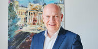 Kai Wegner vor einem Bild des Brandenburger Tores