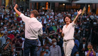 Robert Habeck und Annalena Baerbock vor einer Menschenmenge, Habeck ist von hinten zu sehen, beide tragen weiße Hemden