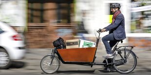 Ein Lastenradfahrer im Stadtverkehr