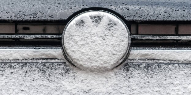Ein schneebedecktes VW-Logo an einem Auto