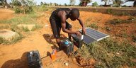 Ein Mann lädt eine Batterie mit Hilfe einer Solarzelle auf