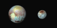 Ein etwas unscharfes Bild von Pluto und einem seiner Monde.