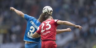 Zwei Fussballspieler spielen den Ball mit dem Kopf