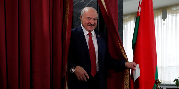 Lukaschenko verlässt mit Wahlzettel die Wahlkabine