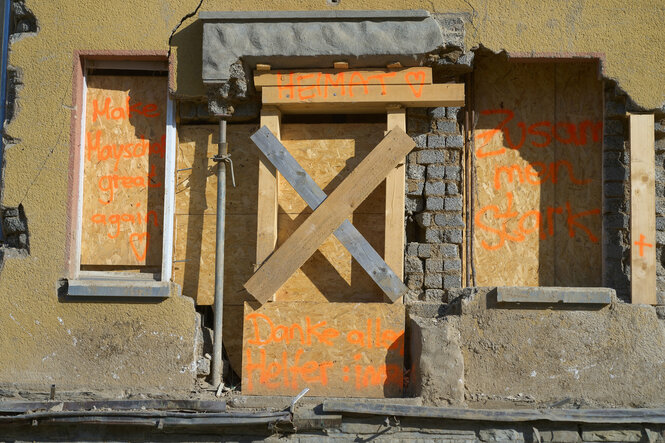 Das Wort "Heimat" und ein Herz sind auf dem Querbalken der verbarrikadierten Ruine eines Wohnhauses zu lesen