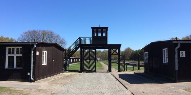 Zwei Baracken stehen links und rechts neben dem Tor zum Konzentrationslager Stutthof
