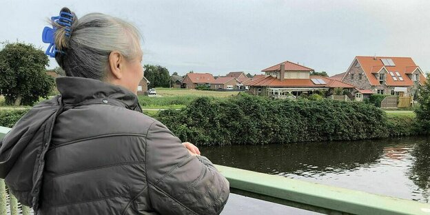 Manuela Ammler steht auf einer Brücke und blickt aufs Wasser