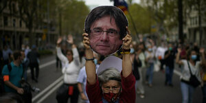 Eine Frau hält einen aus Pappe ausgeschnittenen Kopf des ehemaligen katalanischen Regierungschefs Puigdemont in die Höhe, während einer Demonstration zur Unterstützung Puigdemonts vor dem italienischen Konsulat