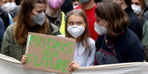 Greta Thunberg hält ein Klimaprotestplakat hoch