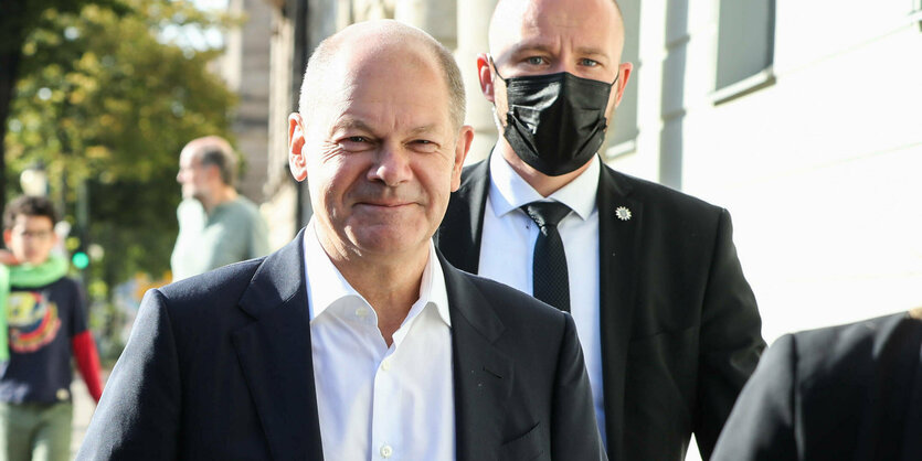 Olaf Scholz vor seinem Wahlokal. Im Hintergrund ein Bodyguard