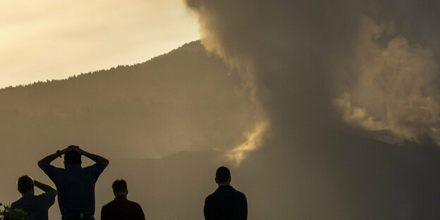 Menschen schauen zur Rauchwolke des Vulkans