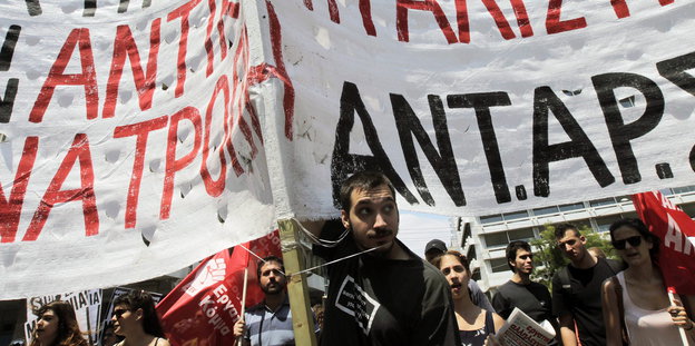 Menschen mit Bannern protestieren in Athen.