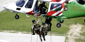 Ein Hubschrauber, zwei Soldaten seilen sich ab.