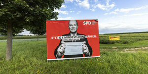 Wahlplakat mit Olaf Scholz auf einer grünen Wiese
