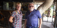In einem Pferdestall stehen eine junge blonde Frau und ihr Vater