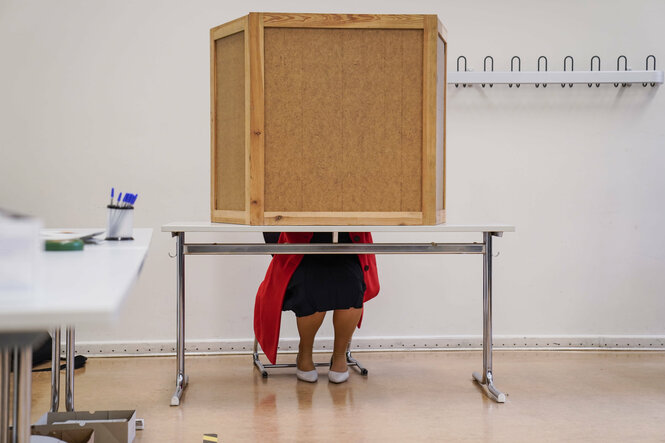 Franziska Giffey sitzt in der Wahlkabine in ihrem Wahlbezirk Friedrichshain, ist also nicht zu erkennen, weil sie hinter der Wahlkabine sitzt