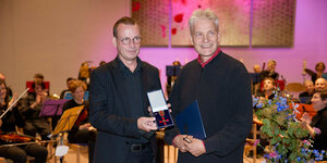 Der Staatssekretär für Kultur Torsten Wöhlert übergibt Michael Knoch das Bundesverdienstkreuz