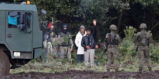 Ein ponishcer Pnazer und Soldaten an der Grenze, ein Geflüchteter winkt