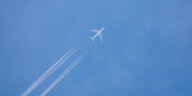 Fluzgeug mit Kondensstreifen am blauen Himmel