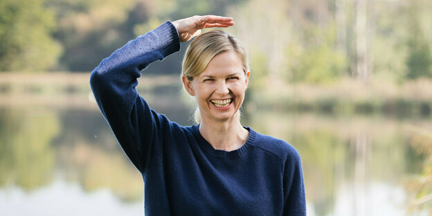 Britta Steffen hält sich eine Hand über den Kopf und lacht.