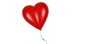 Roter Herz-Ballon mit grüner Schnur fliegt