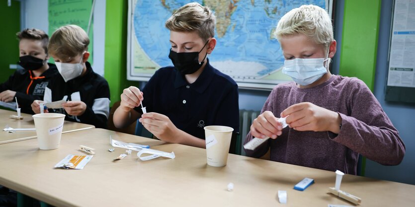 Kinder mit Masken und Corona-Schnelltests