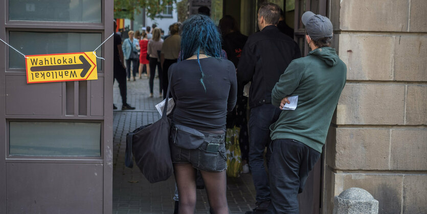 Menschen stehen vor einem Wahllokal in Berlin