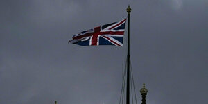 Britische Fahne vor düsterem Himmel