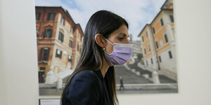 Virginia Raggi steht vor einem Gemälde der Spanischen Treppe in Rom