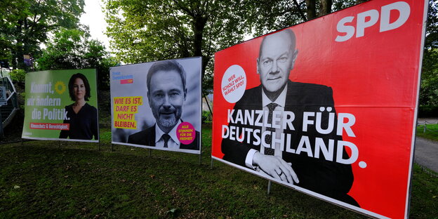 Wahlplakat von SPD, FDP und Grünen auf einer Grünfläche.