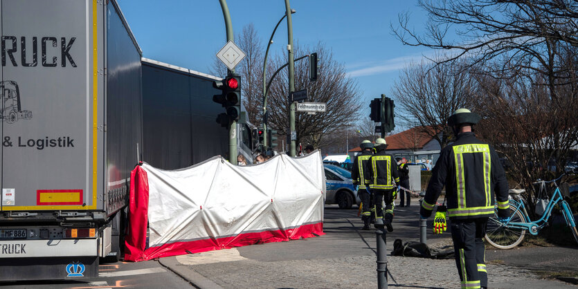 Ein Lastwagen steht mitten auf einer Kreuzung, ein Sichtschutz verhindert den Blick auf das Opfer