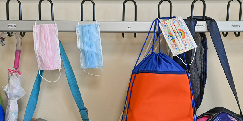 Masken hängen an einer Garderobe in einer Schule