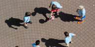 Fünf Jungendliche spielen auf einem Hof Fußball