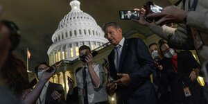 Vor dem Hintergrund des angeleuchteten Kapitols in Washington spricht Senator Joe Manchin mit der Presse
