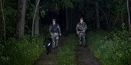 Grenzschutzbeamte mit Hund im Wald.