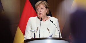Merkel vor deutscher Fahne.