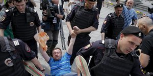 Ein Menschenrechtsaktivist wird von der russischen Polizei weggetragen