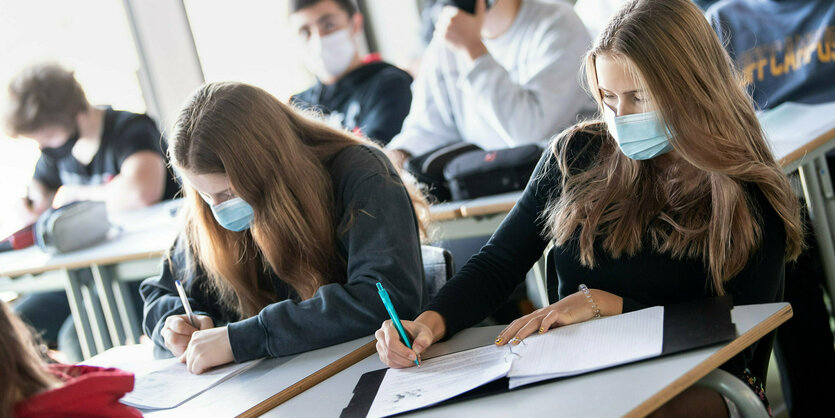 Schüler*innen mit Mund- und Nasenschutz.