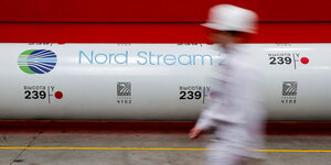 Arbeiter geht an einem Rohr mit der Aufschrift "Nord Stream" vorbei