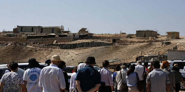 EU-Vertreter schauen über eine Mauer auf das Dorf Masafer Yatta