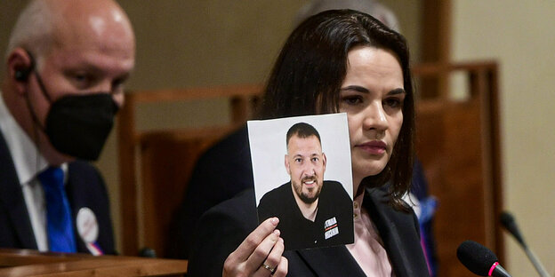 Tichanowslaja hält ein Foto ihres Inhaftierten Mannes in der Hand