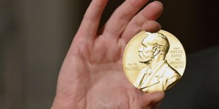 Eine Nobelmedaille wird während einer Zeremonie in New York hochgehalten.