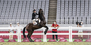 Eine Reiterin auf einem scheuenden Pferd in einem Stadion