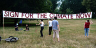 Menschen in Park, Banner: "Sign for the climate now"