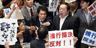 Politiker der Opposition protestiert mit Schildern gegen die Pläne der Regierung