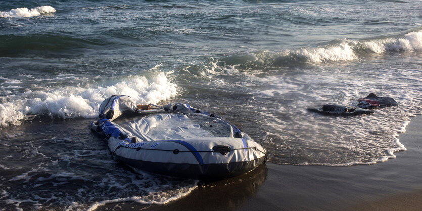 Ein zerstörtes Schlauboot am Strand.